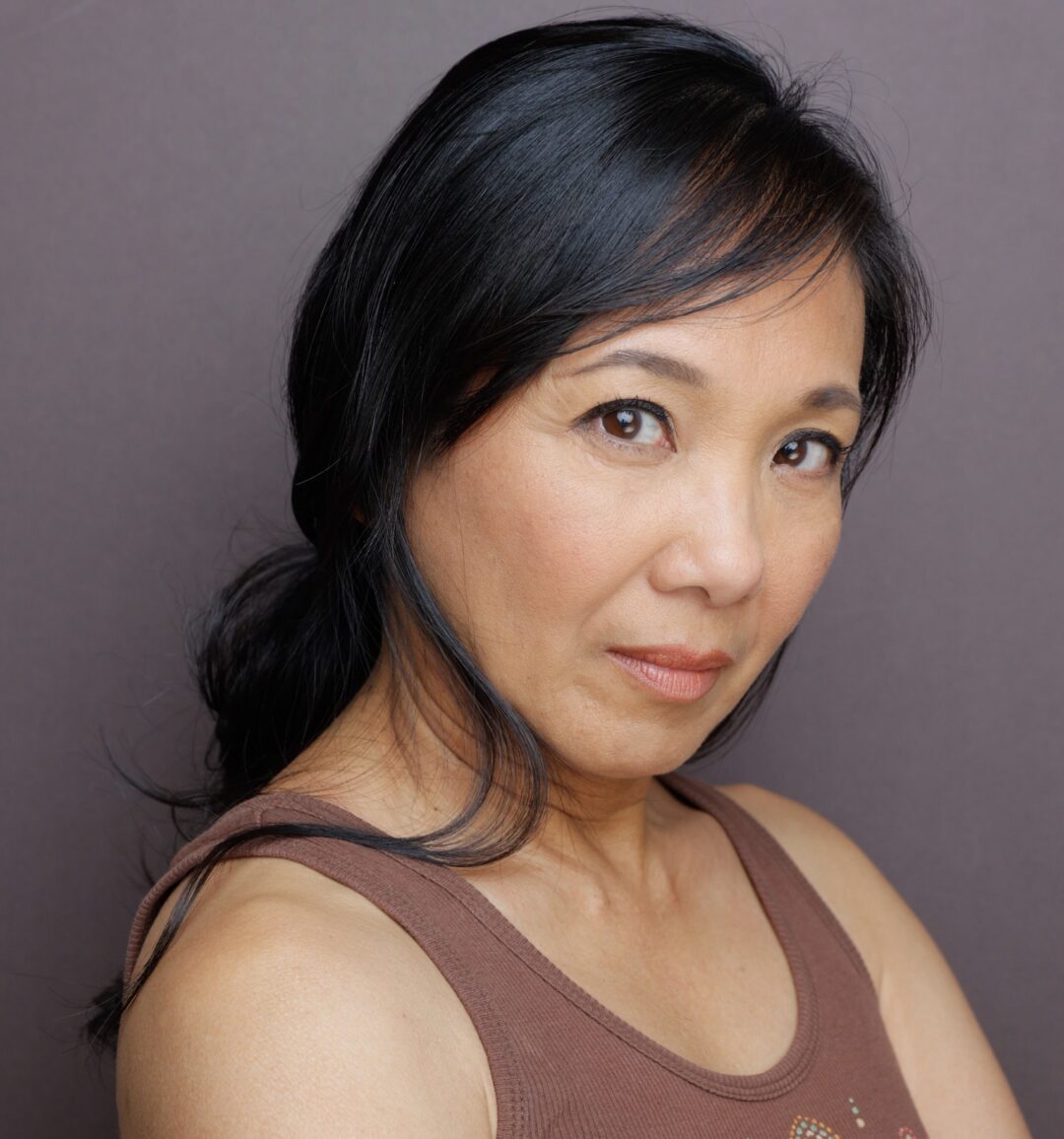 Jennifer Aquino with hair back and in a brown tank